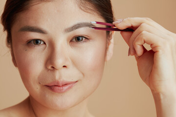 Portrait of young asian woman with tweezers