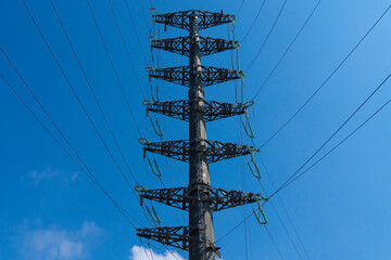Construction site with new power poles on an overhead line. High voltage power energy transmission towers Have a complex steel structure In the evening.