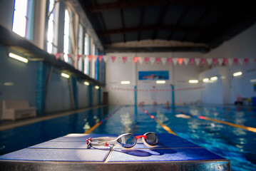 Swimming goggles against the background of a sports swimming pool.