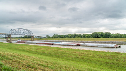 Towboat with barges is passing under a bridge on the Chain of Rocks Canal of MIssissippi River above St Louis - obrazy, fototapety, plakaty