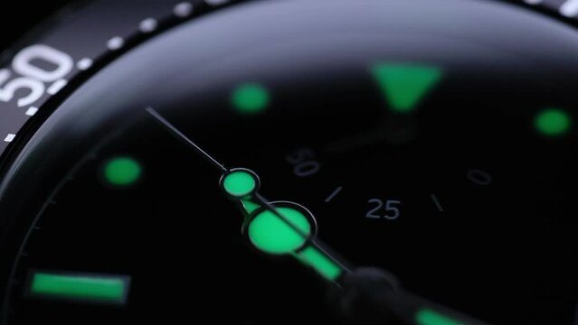 the second hand is ticking. Light flash on the turning clockface. Running second arrow. phosphor watch. phosphor watch. back light luxury watch under water. lume shot of a watch.