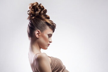 Side view portrait of beautiful brunette young woman with stylish hairdo and makeup, looking away,...