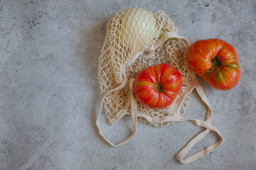 String bag with fresh tomatoes on white background