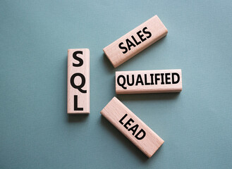 SQL - Sales Qualified Lead. Wooden cubes with words SQL. Beautiful grey green background. Business and SQL concept. Copy space.