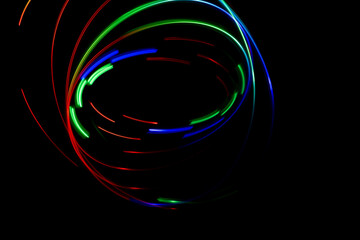 long exposure of light swirrling around making a pattern, red, blue, green light making a background
