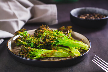 Fried green broccoli sprouts on a plate on the table