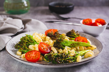 Pasta with cherry tomatoes and fried broccoli sprouts on a plate