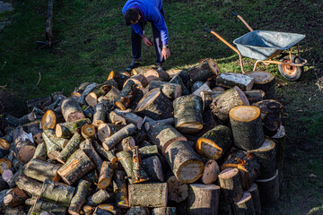 Man chopping wood with an ax in his hand. Standing by a log for chopping wood.
