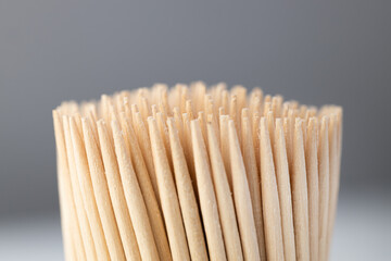 Toothpicks in a box on a gray background, close-up