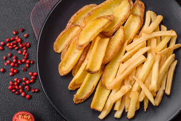 Delicious crispy french fries with salt and spices on a textured concrete background