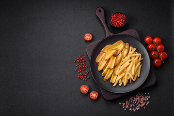 Delicious crispy french fries with salt and spices on a textured concrete background