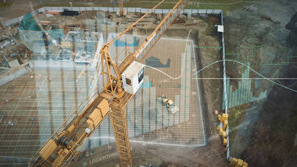 Yellow crane in construction site with graphics for production trend and control of workers team....