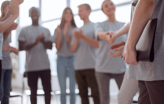 blurred image of a group of young people sitting in a circle