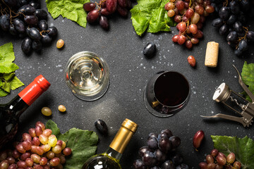 Wine set at black background. White and red wine, Glass of wine, bottle and fresh crape. Top view with copy space.