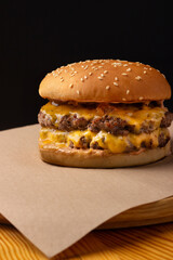 double burger with cheese on baking paper.