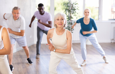 Senior woman and friends people dancing in studio or gym doing sports or practicing dance number. Physical activity, good bodily shape