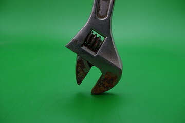 a wrench on a green background. wrench that has started to rust.