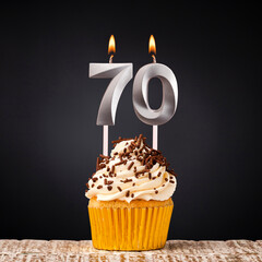 Birthday candle number 70 - Anniversary cupcake on black background