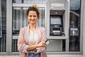 Fototapeta na wymiar Portrait of adult caucasian woman stand in front of ATM machine