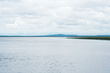 natural landscape, vast shallow lake with reed banks on a rainy day