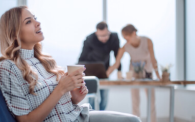 young business woman with a Cup of coffee in a modern office