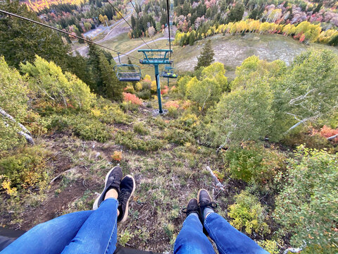 Personal perspective view of two women's legs outstretched on a ski lift, Sundance, Utah, USA