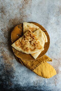 Overhead view of Georgian cheese bread slices (Imeruli khachapuri) on a plate