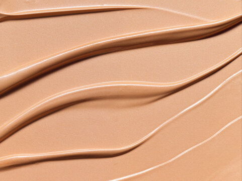 Makeup Liquid foundation composition background. BB CC Cream Concealer texture. Cosmetic product brush swatch
