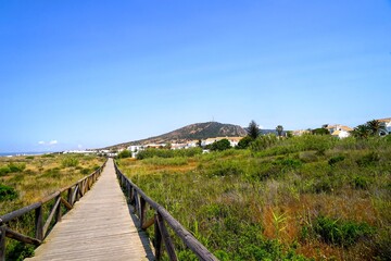 Fototapeta na wymiar wooden walkway to access the beach through the dunes near Zahara de los Atunes, Costa de la Luz, Andalusia, Cádiz, Spain