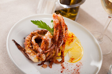 Deep fried crispy squid tentacles served with boiled potatoes, fresh lemon and greens..
