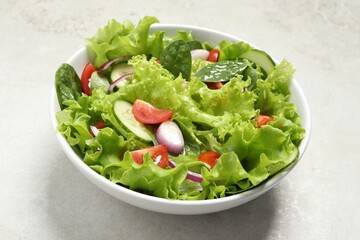 Delicious salad in bowl on light grey table