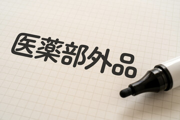 医薬部外品と書かれたノートとマーカー