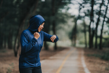 Happy cheerful Middle-aged Asian Muslim woman practicing exercise and stretching and enjoy jogging at the park close up with copy space. Modern muslim woman lifestyles and diversity concept.