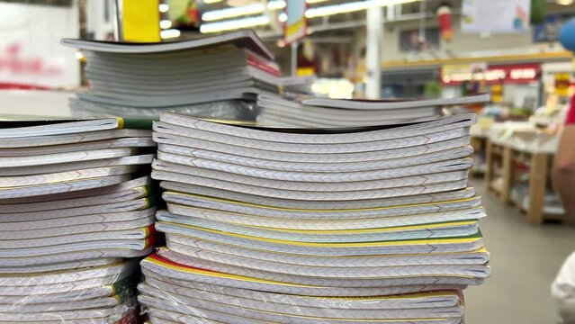 New school notebooks lie in stacks at the school supply store until the first of September