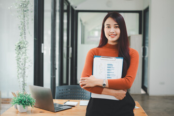 Female operations manager holds meeting presentation for a team of economists. Asian woman uses business paper with Growth Analysis, Charts, Statistics and Data..