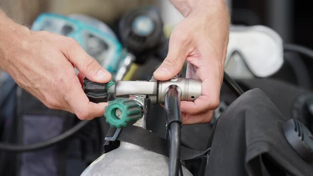 Person fitting scuba dive regulator on tank valve, diving holiday adventure