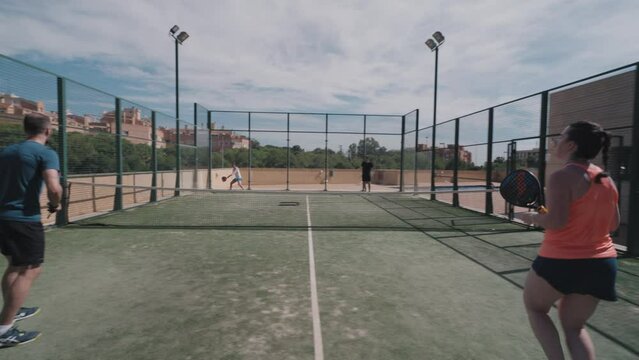 Padel tennis match. Service, lob shot and smash that gets the ball out of court.