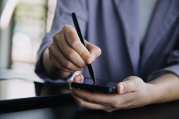 Asian Business woman using calculator and laptop for doing math finance on an office desk, tax, report, accounting, statistics, and analytical research concept