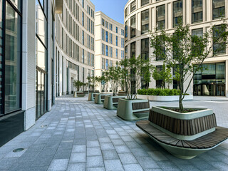 modern office buildings courtyard with row of trees and benches. - 634529726