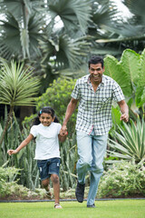 Happy Indian dad and his child playing outdoors