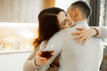 Young couple in love drinking red wine at kitchen. Love and romantic.