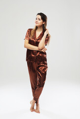 Lifestyle, fashion and people concept: beautiful young female with long hair dressed in brown pajama
