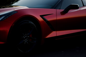 An aesthetic shot of a red sports coupe. Close-up shot of the rear wing of the car and the wheel...