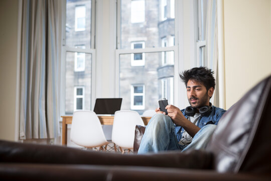 Indian Man Using His Phone At Home.