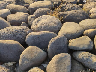piles of large natural stones for breaking waves in the harbor that form a beautiful textured