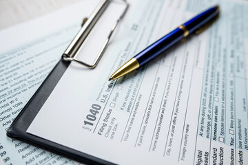 Concept of filling in 1040 tax return form with pen