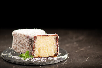 Delectable soft and fluffy Australian lamington made with sponge cake, chocolate sauce and shredded coconut.