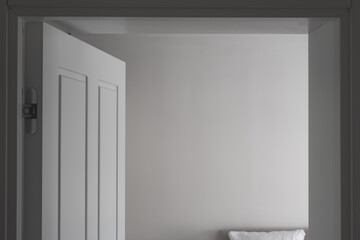Wide open bedroom door with clean white wall as copy space
