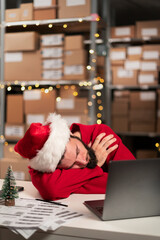 Young warehouse worker sleeping tired from overtime work on christmas eve