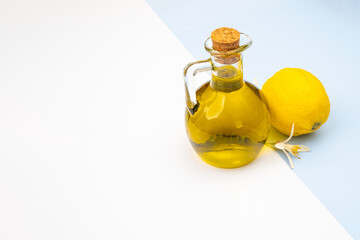A flask of fresh extra virgin olive oil with lemon and vanilla on a sky-white background as a mediterranean cuisine concept